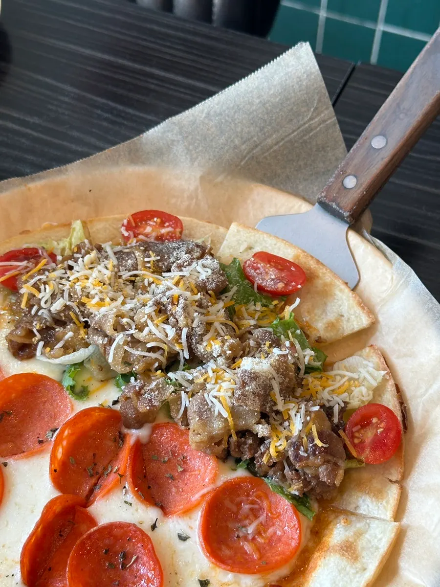 A slice of bulgogi salad pizza with stretchy cheese