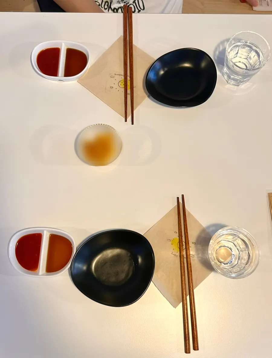 Vinegar-chili sauce, soy sauce, and pickled radish on the table