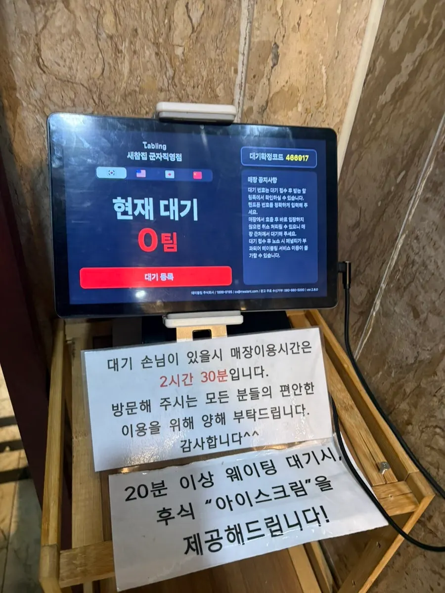 Saechamjip menu board showing photos of Korean side dishes
