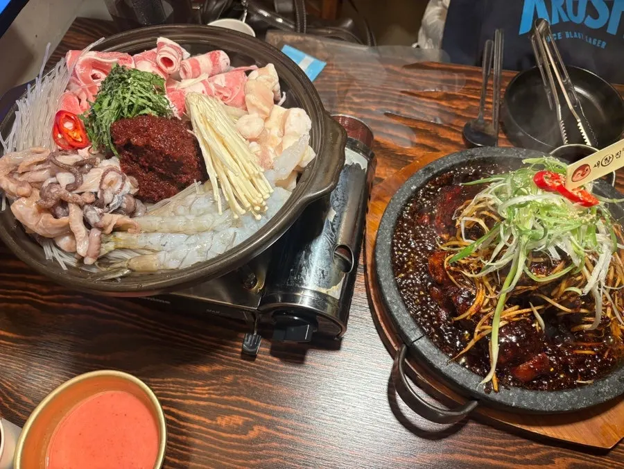 Full spread of bone grill, nakgopsae hot pot, and makgeolli