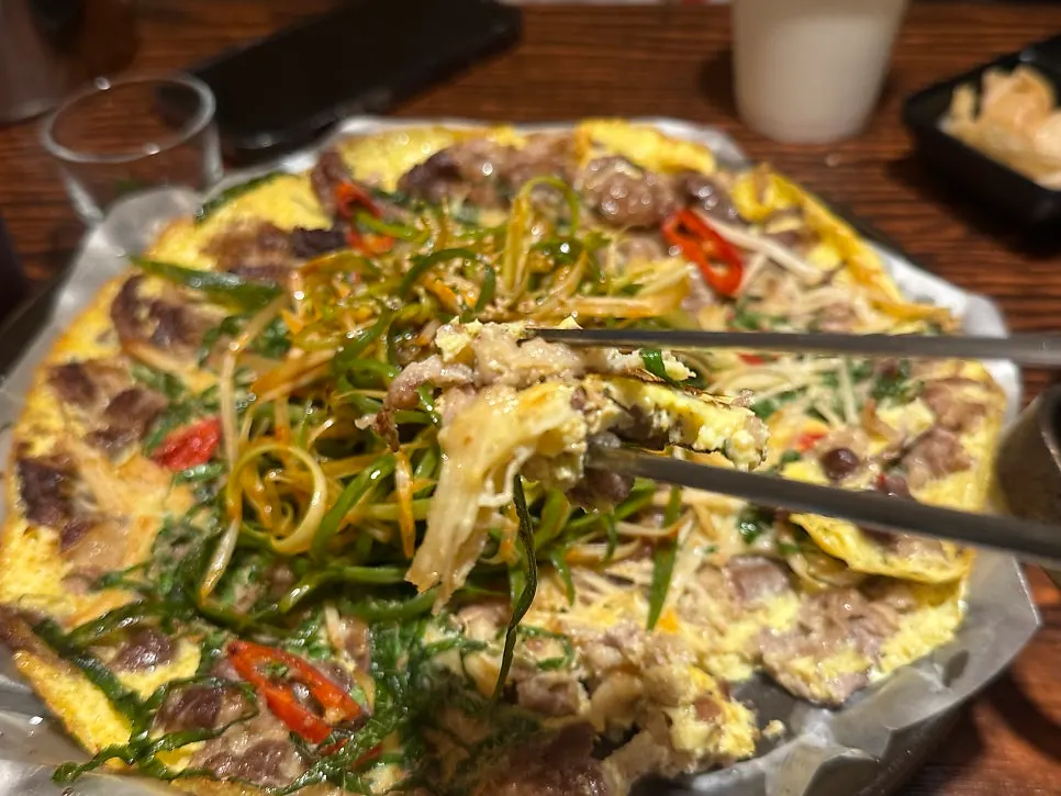 A bite of beef yukjeon topped with scallion salad