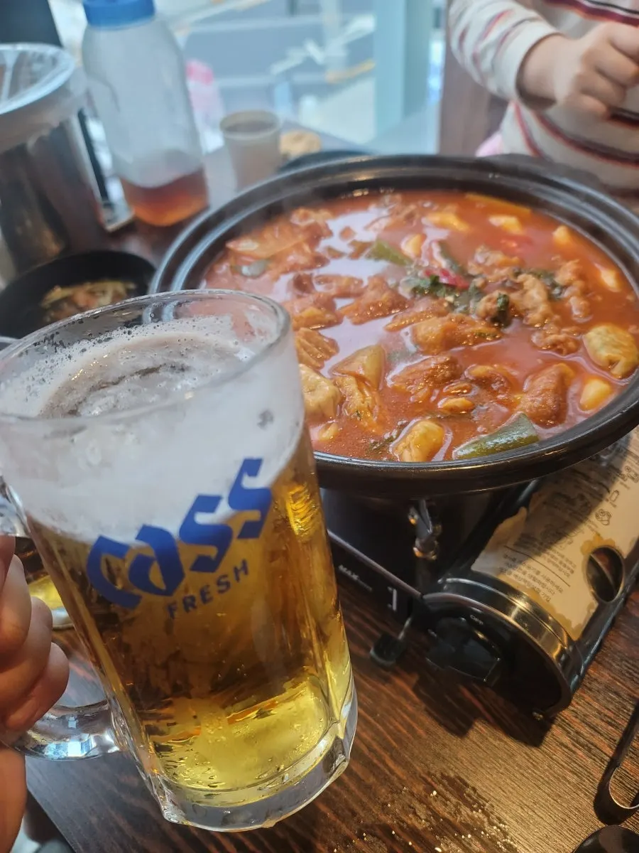 A piece of fried odeng dipped in tteokbokki sauce
