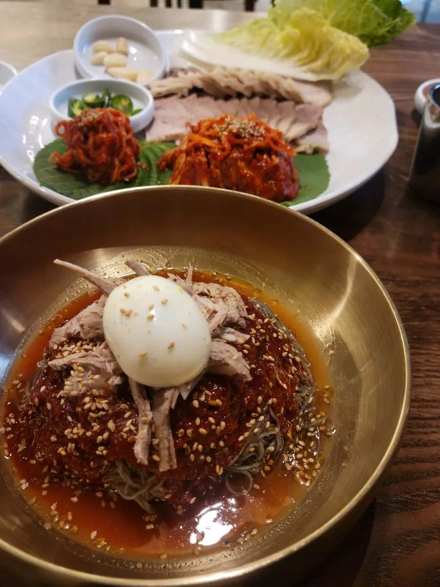 Table spread with bibim naengmyeon and bossam together