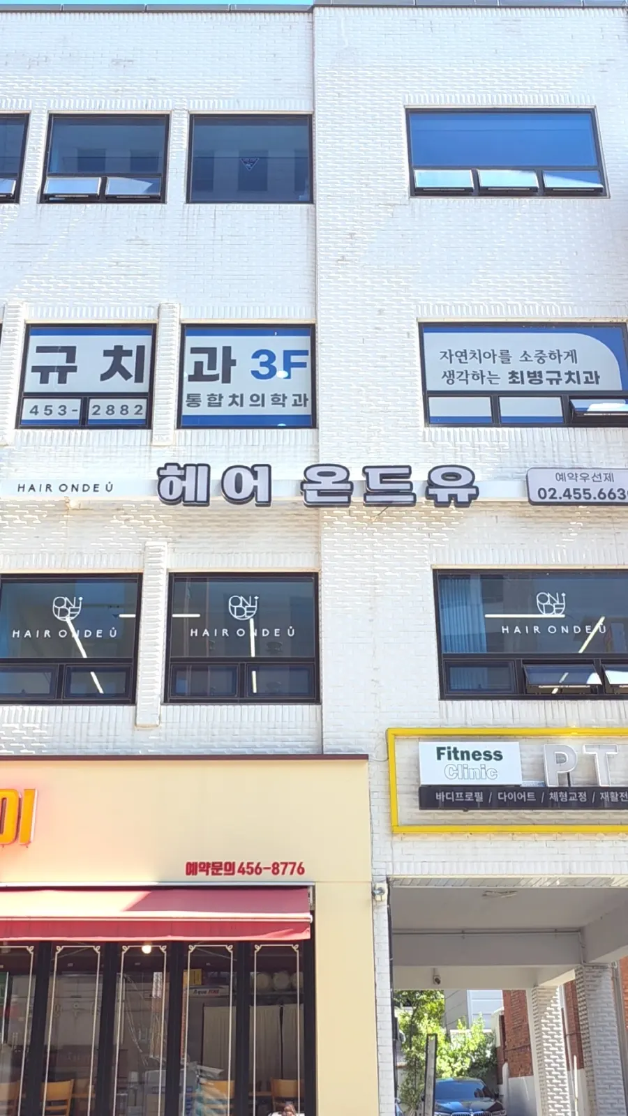 Salon sign on the 2nd floor of a café building along the main road near Gunja Station Exit 5
