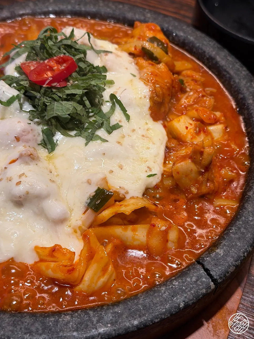 Cheesy dakgalbi bubbling on the stone plate