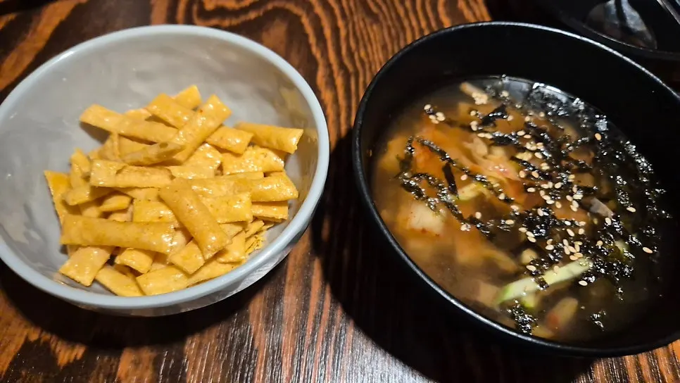 A glass of beer with the complimentary side dishes