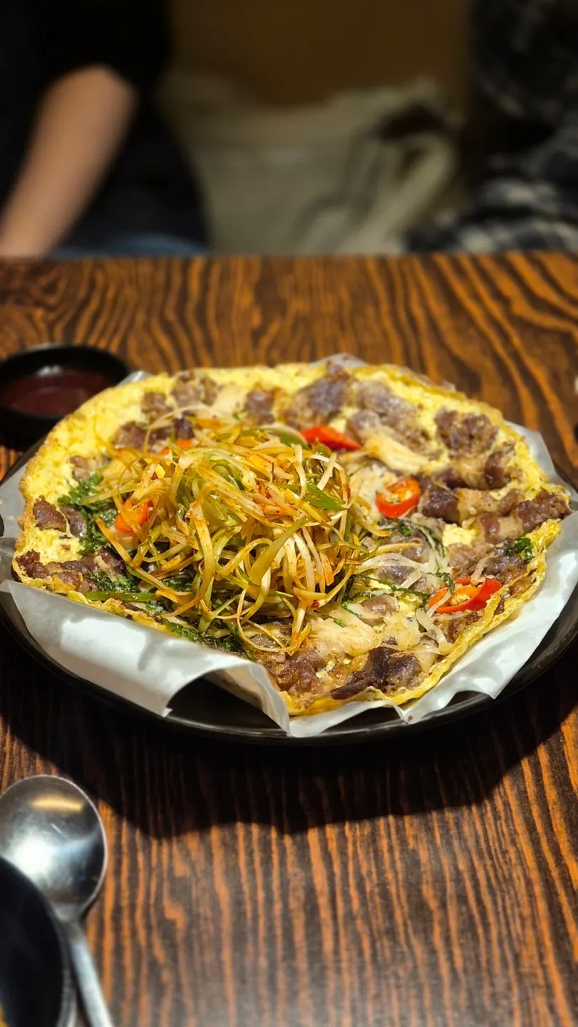 Vertical photo of beef yukjeon topped with scallion salad