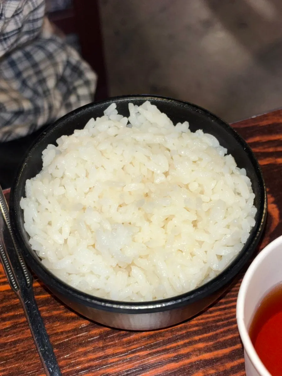 A bite-sized piece of bone grill topped with scallions and cheese