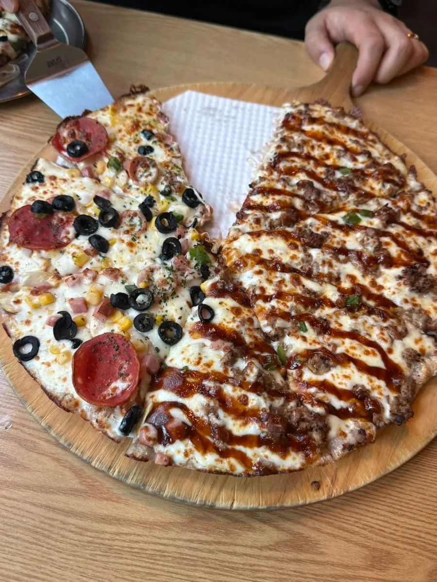 A pizza slice with stretchy melted cheese