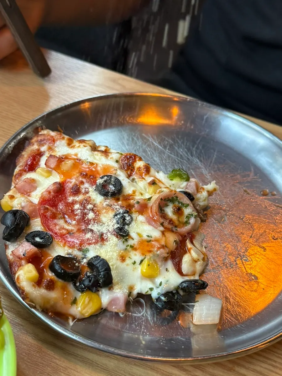 Pizza topped with hot sauce and parmesan cheese