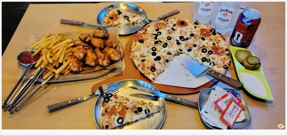 A slice of combination pizza with cheese stretching long