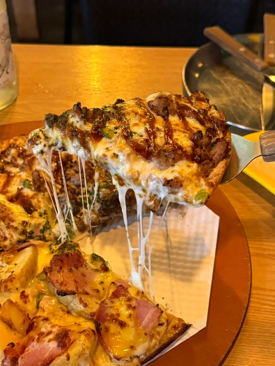 A slice of pizza piled high with toppings