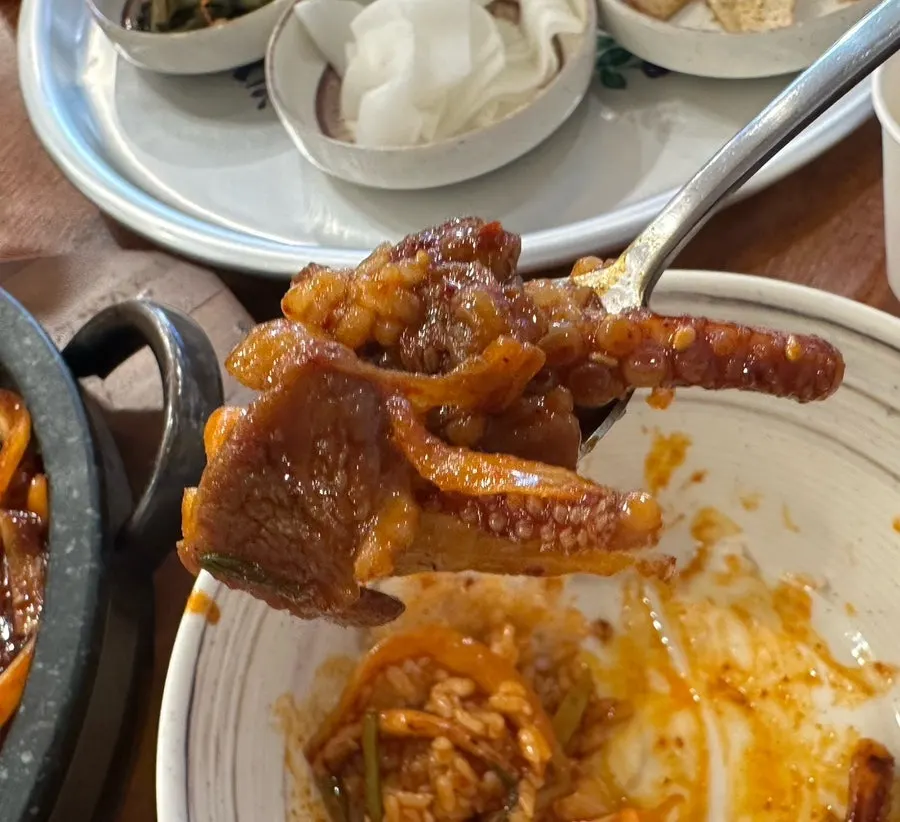 Oje bokkeum piled onto rice with a drizzle of sesame oil