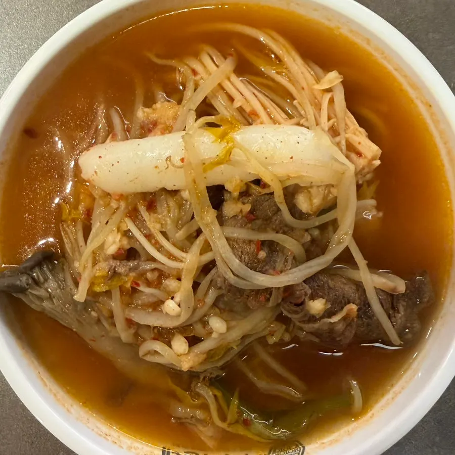 A piece dipped in the dedicated shabu-shabu sauce