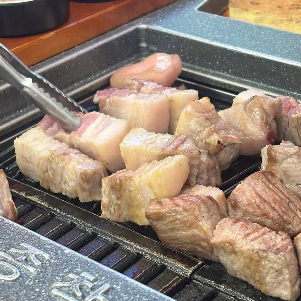 Salt-grilled pork chunks cooking on the grill