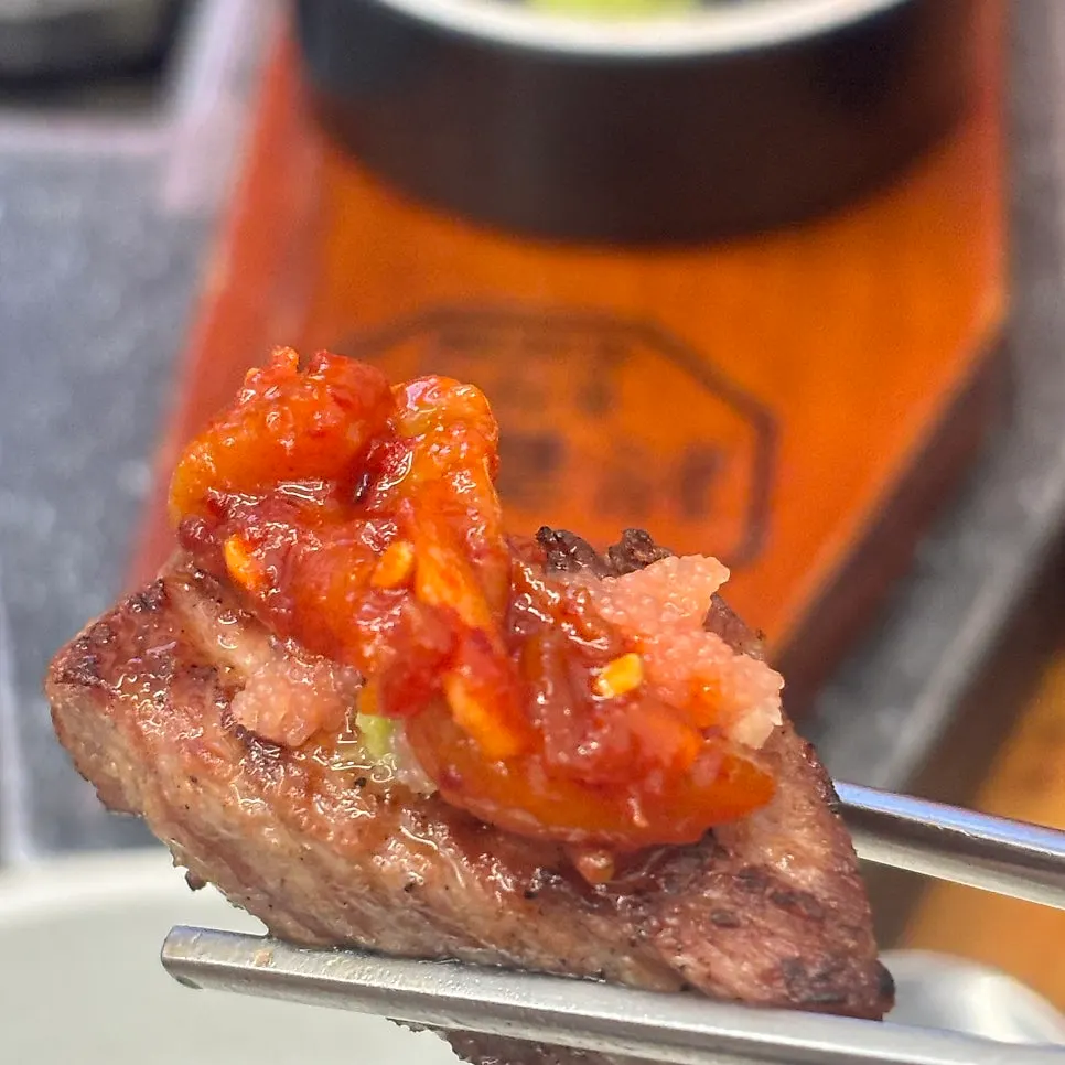 A piece of meat topped with pollock roe and squid jeotgal