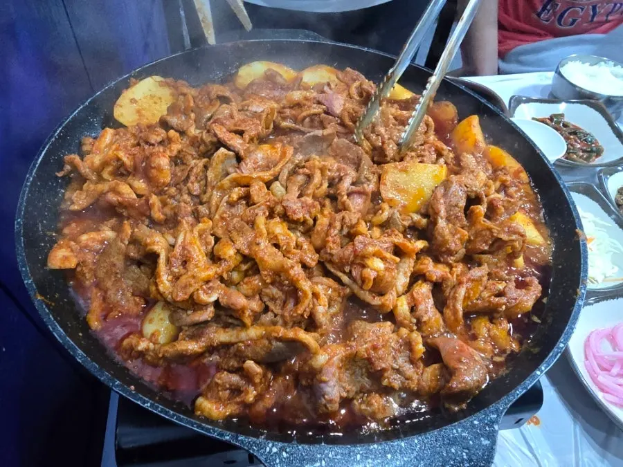 Spicy stir-fried duck simmering down on the hot plate