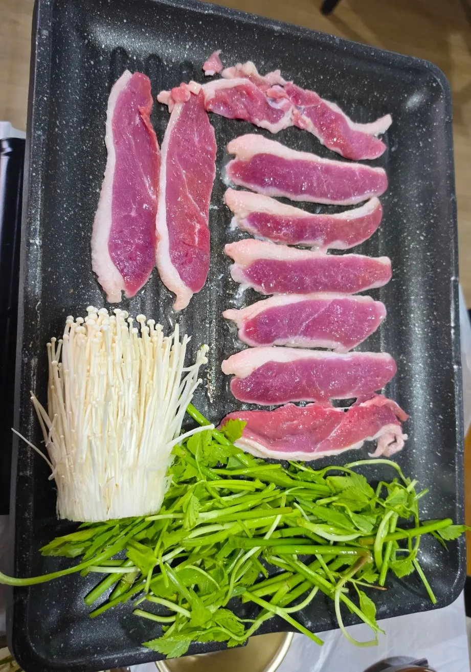Raw duck roast and minari on the grill pan