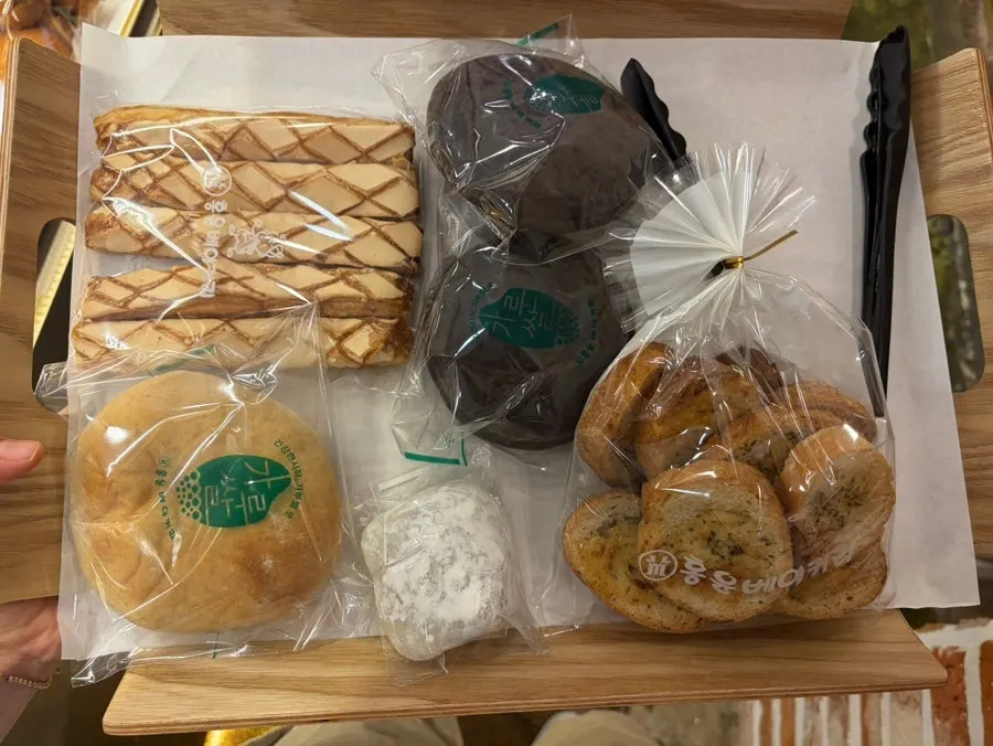 The four purchased items: handmade chocopie, garlic bread, red bean rice bread, and chapssaltteok