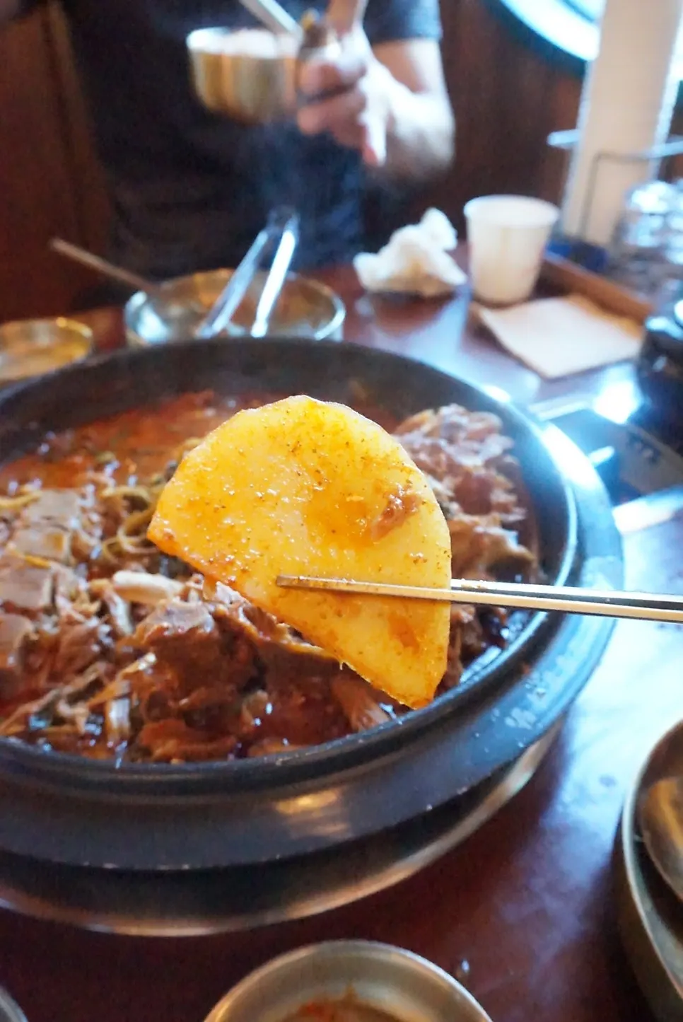 A scoop of broth and gamjatang ingredients