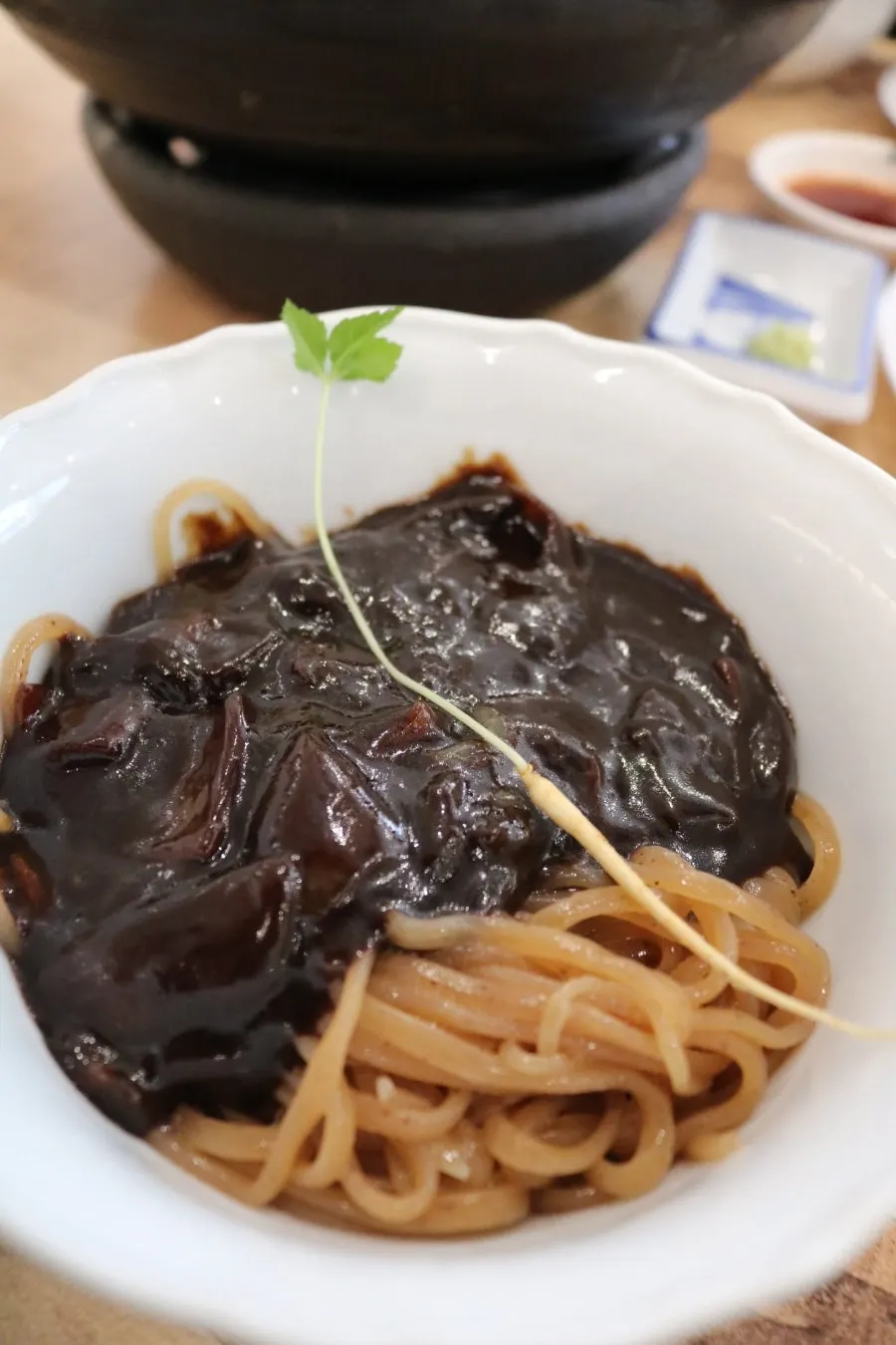 Chewy jjambbong noodles lifted with chopsticks