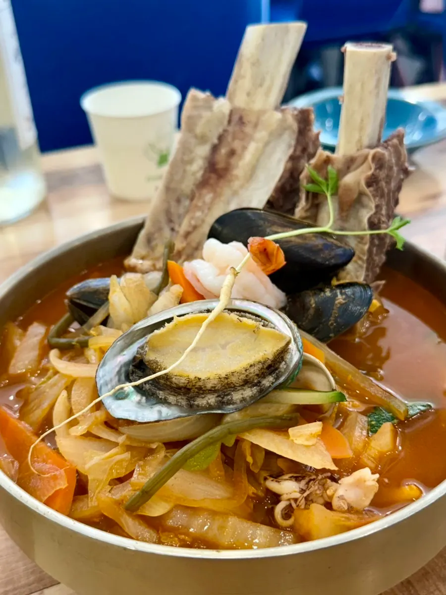 A full spread of premium galbi abalone jjambbong, seafood jjajang platter, and half-and-half sweet and sour pork
