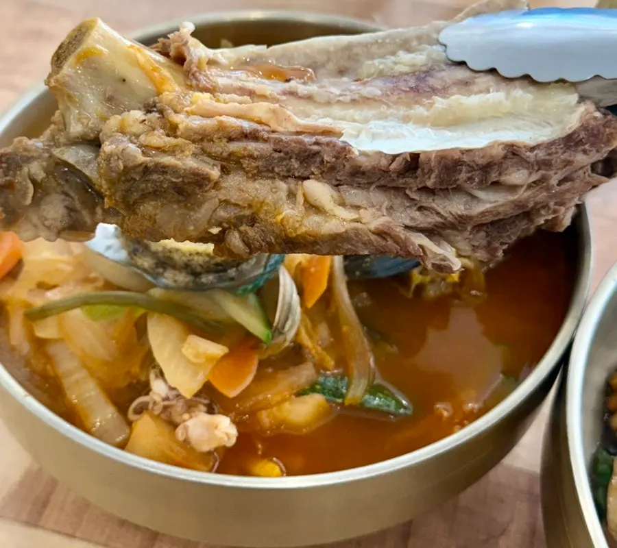 Jjambbong topped with a whole rib and abalone