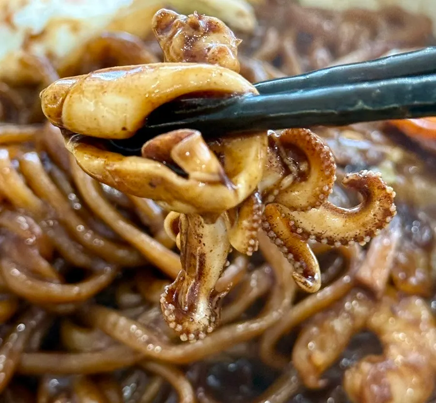 Seafood jjajang platter sprinkled with red pepper flakes