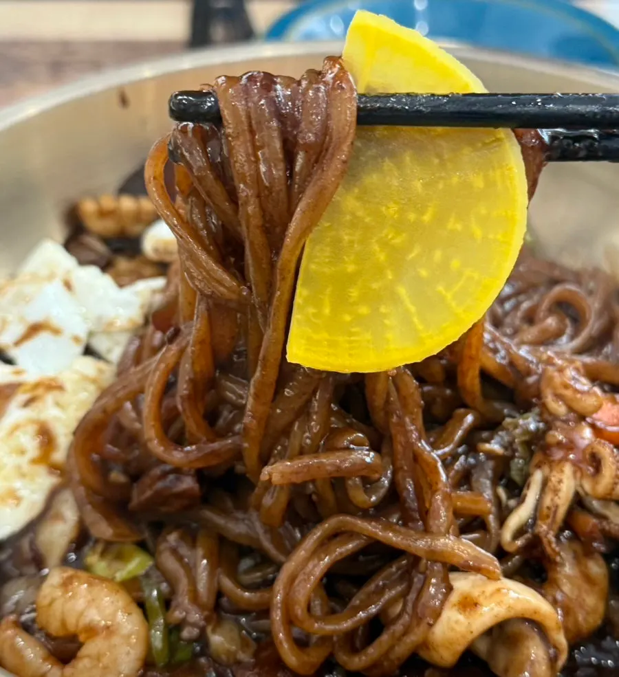 Seafood jjajang platter topped with an egg yolk