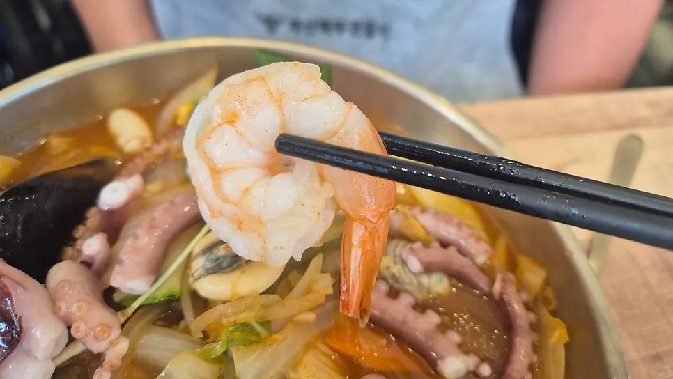 Jjambbong showing a whole abalone inside