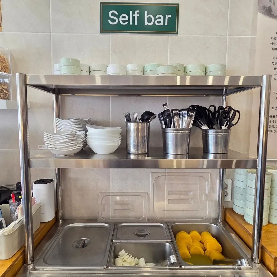 Self-serve bar with side dishes, small plates, and scissors