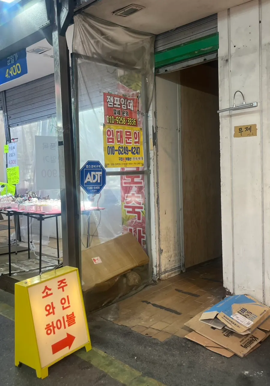 Entrance and business hours sign at Muje in Guri