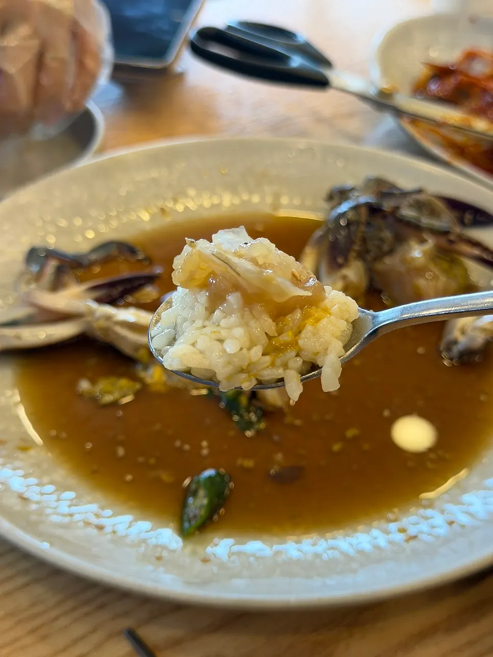 A bite of gut-mixed rice wrapped in seaweed topped with crab meat