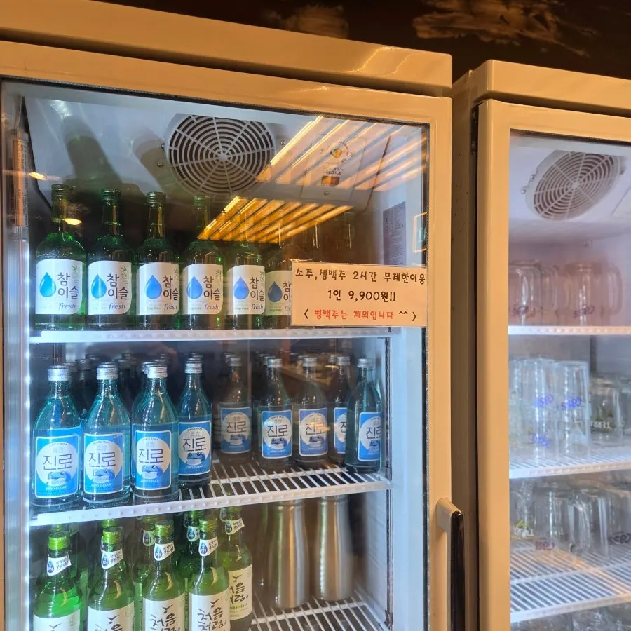 Sign for unlimited alcohol next to the drink self-serve bar