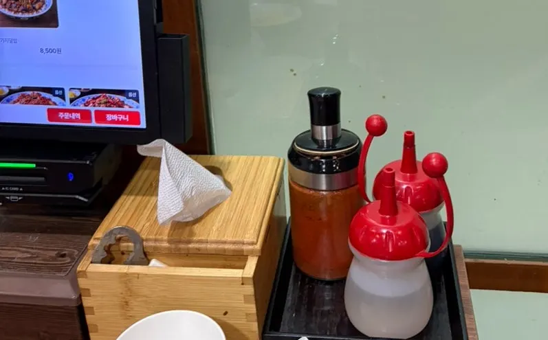 Table with red pepper flakes, vinegar, and soy sauce