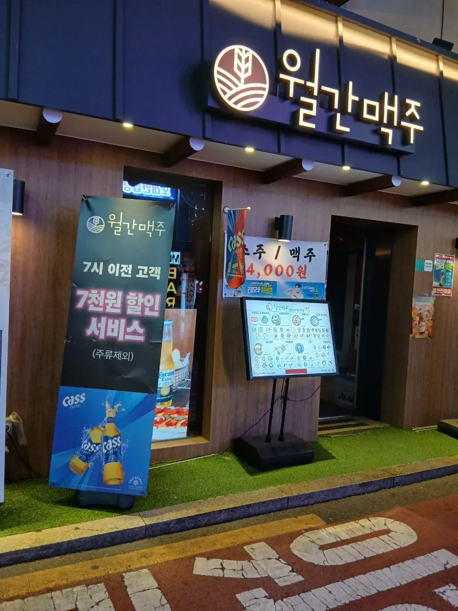 Exterior of Monthly Beer with a black-toned sign and standing signboards