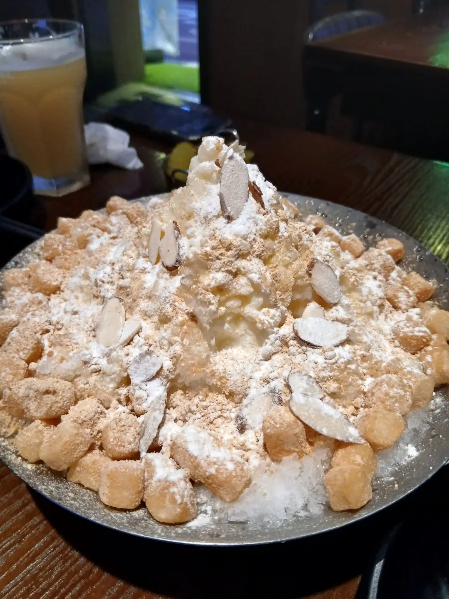 Injeolmi bingsu topped with soybean powder and sliced almonds