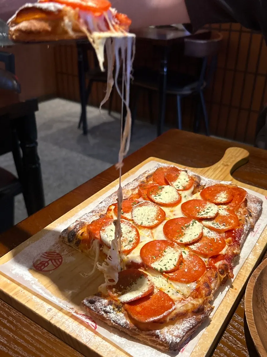 Cheese stretching from a slice of pepperoni pizza
