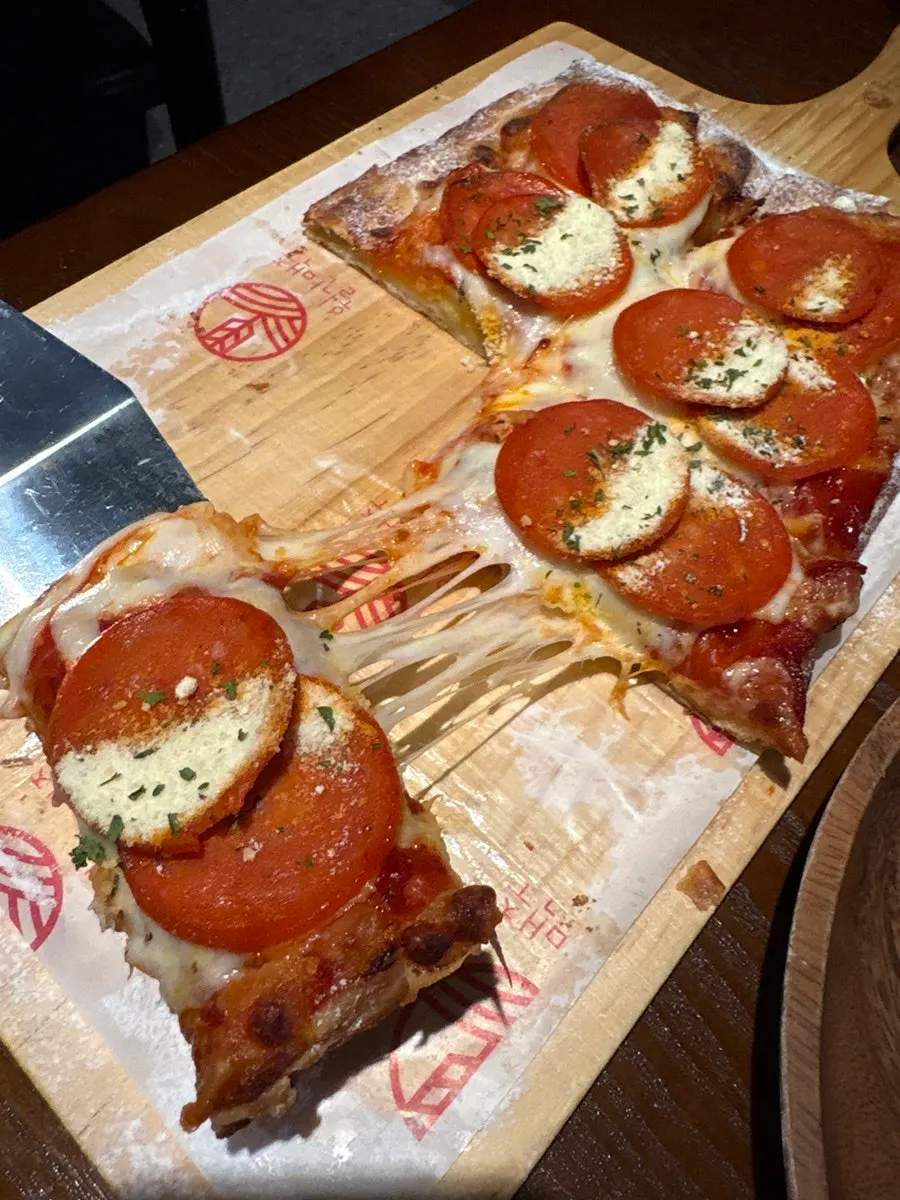 Sharing pepperoni pizza during drinks
