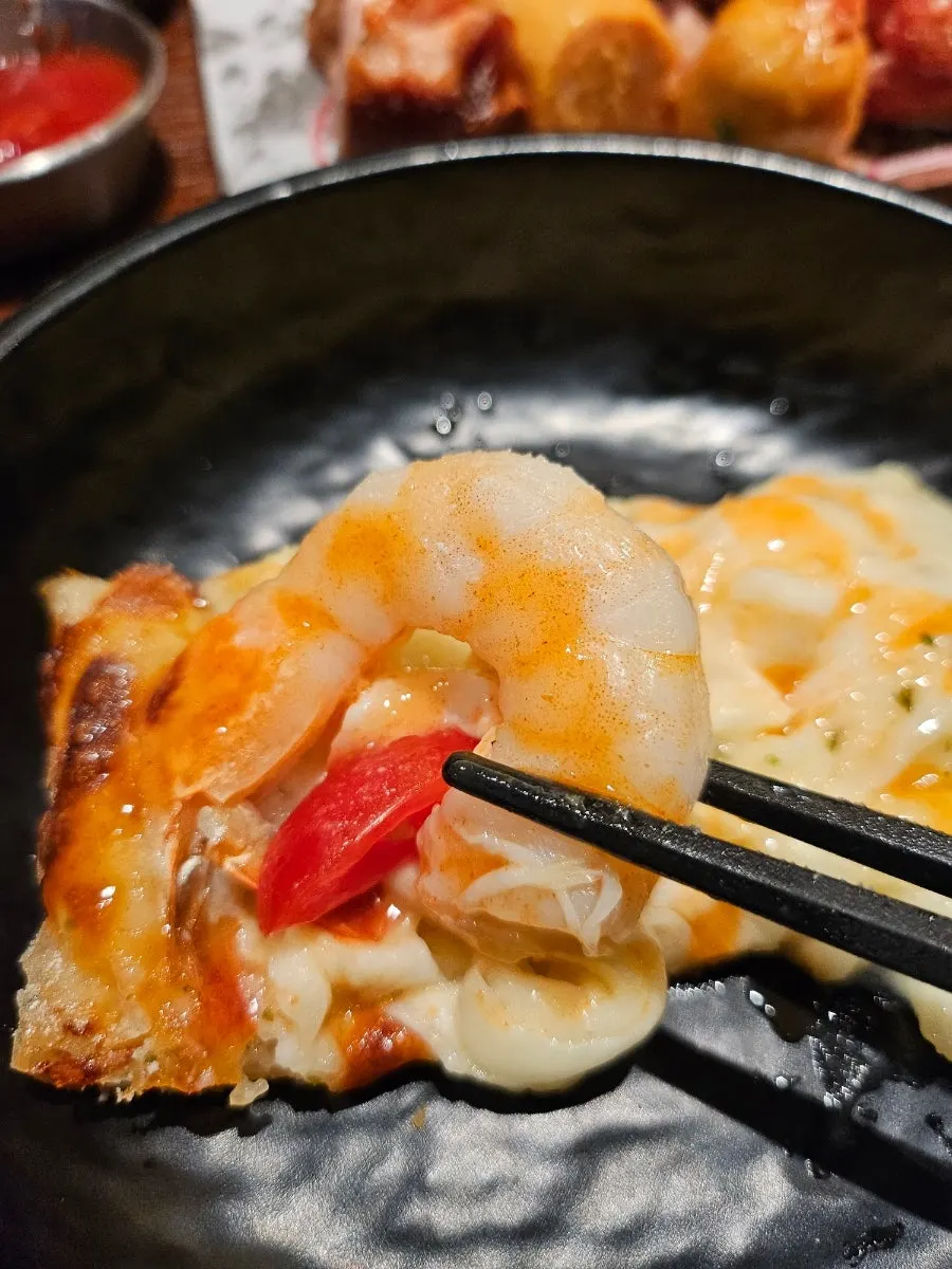 A slice of shrimp pizza piled high with cheese