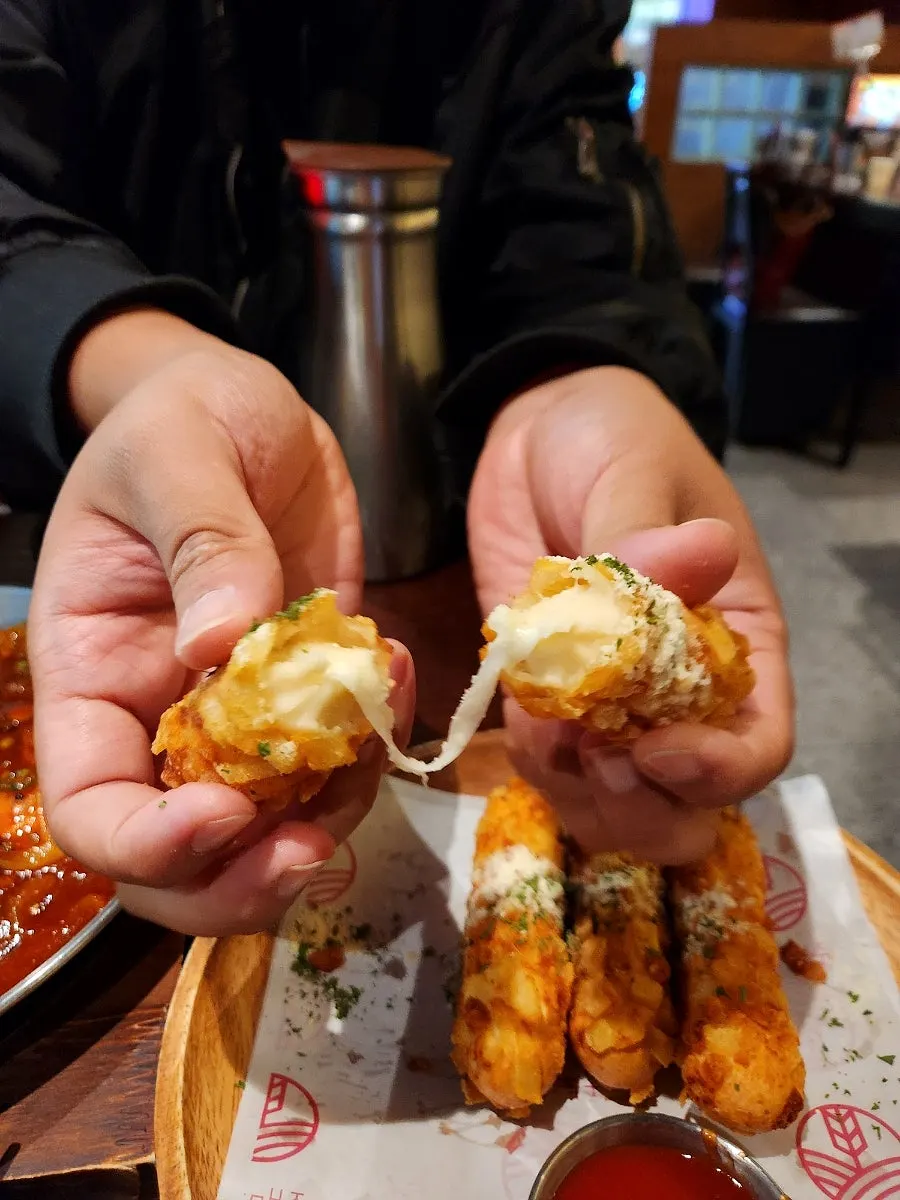 Another shot capturing the cheese pull of the cheese sticks