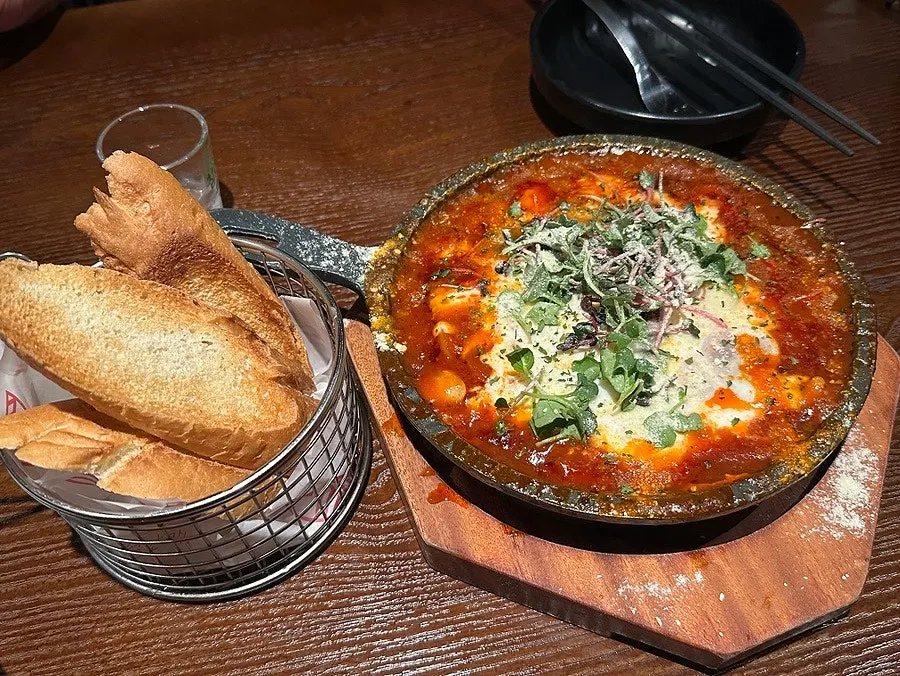 Egg-in-hell snack loaded with tomato sauce and egg