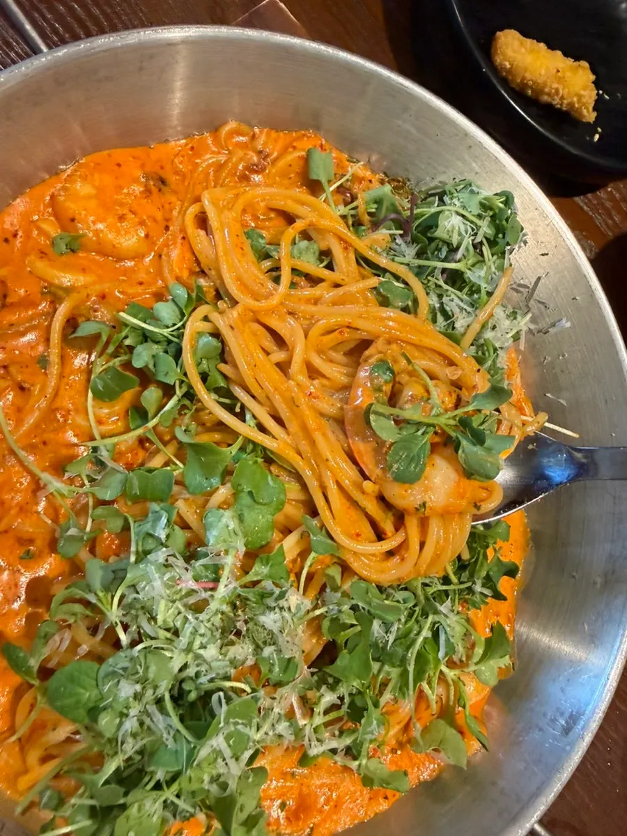 Fork lifting noodles from the jjamppong cream pasta