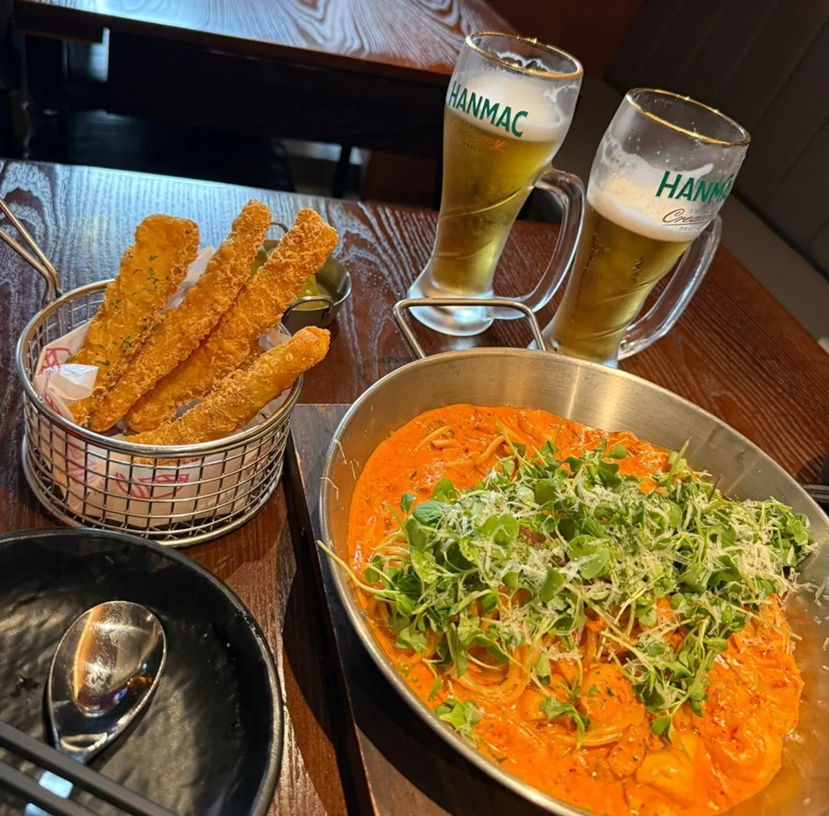Table spread with pasta, fried squid, and draft beer