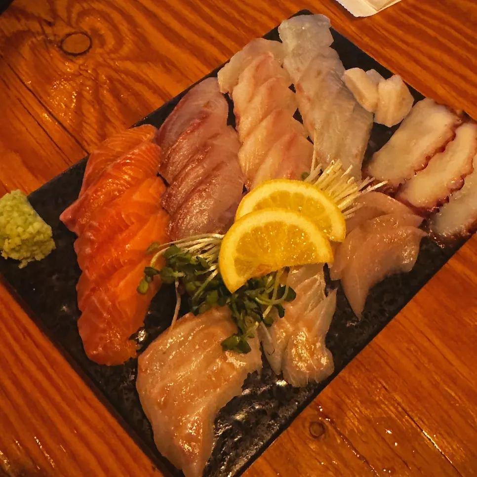 Grilled fish served with lemon, soy sauce, and wasabi