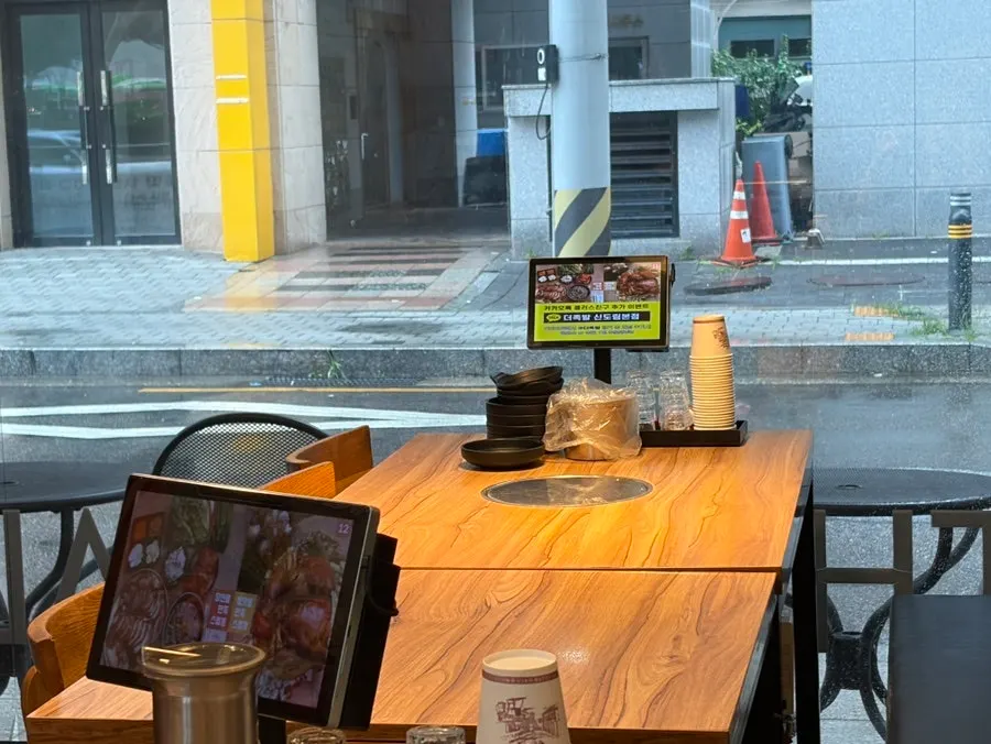 Wide seating with wood-toned tables and tablets