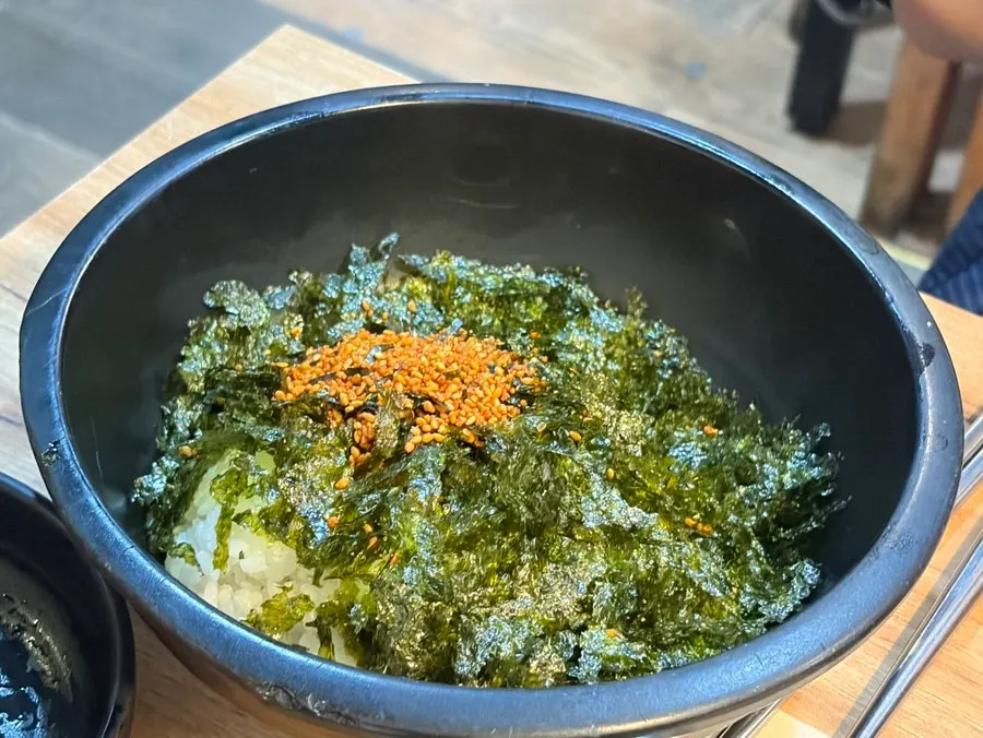Rice balls topped generously with seaweed and sesame seeds