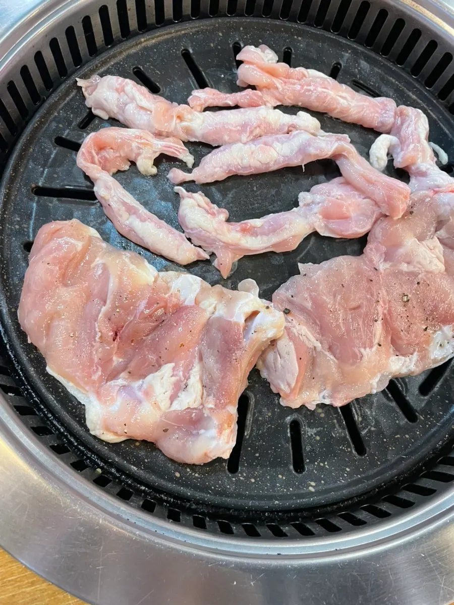 Chicken thigh cooking over charcoal