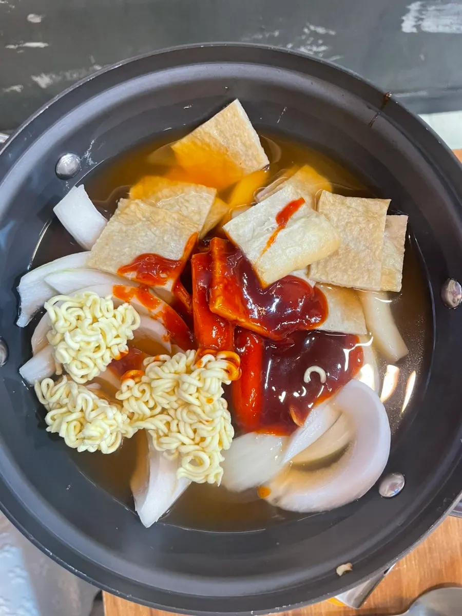 Seasoned dakgalbi grilling over charcoal