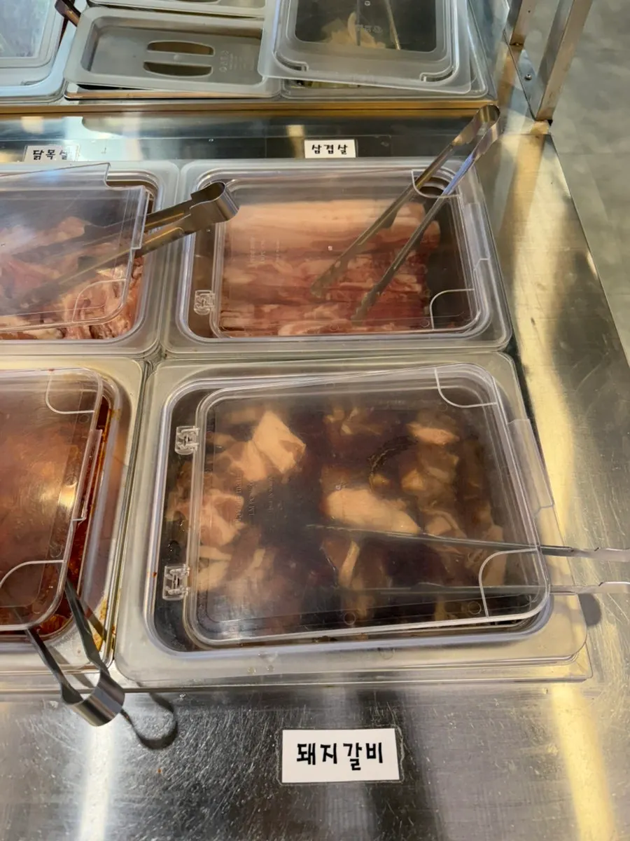 닭갈비와 돼지갈비, 삼겹살이 놓인 셀프바 고기 코너